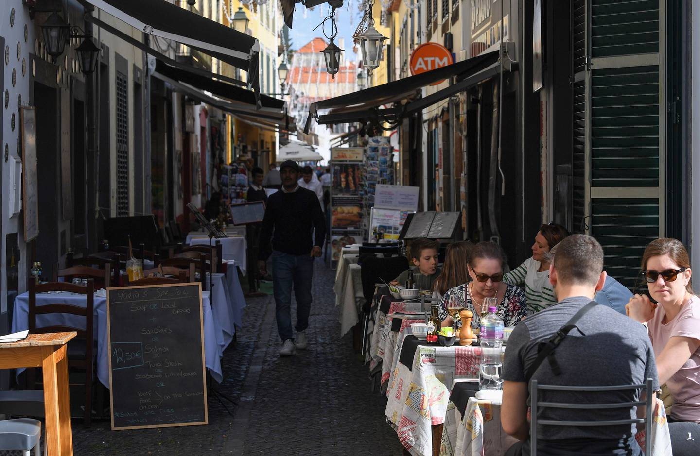 Diners at street tables outside a restaurant in Funchal, Portugal, on Sunday.dfd