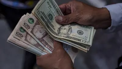 Un cambista cuenta billetes de quetzal y dólar estadounidense en la Ciudad de Guatemala, el viernes 31 de marzo de 2023.