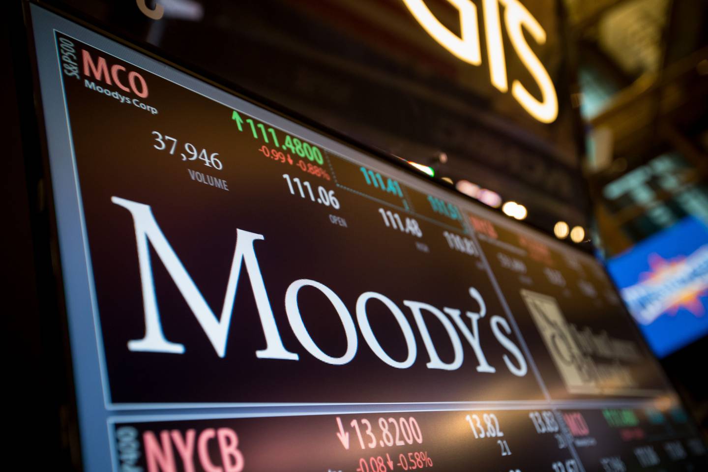 A monitor displays Moody's Corp. signage on the floor of the New York Stock Exchange (NYSE) in New York, U.S., on Monday, March 27, 2017. U.S. stocks fell, extending a decline on Friday after President Trump failed to pass his health-care bill, undermining optimism he can enact growth policies that invigorated bulls after the election. Photographer: Michael Nagle/Bloomberg