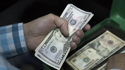 Un empleado cuenta billetes de cincuenta dólares estadounidenses en una casa de cambio.