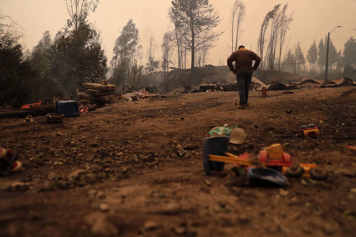 Un residente examina los daños luego de un incendio forestal en Santa Juana, provincia de Concepción, Chile, el 3 de febrero. Fotógrafo: Javier Torres/AFP/Getty Imagesdfd