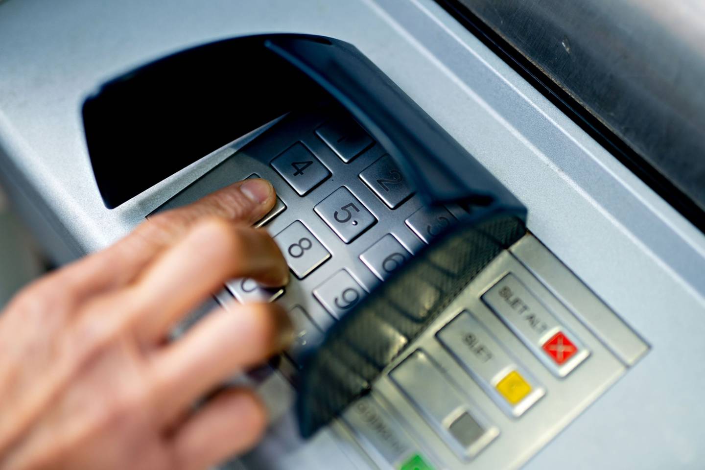 Una persona saca dinero de un cajero automático.