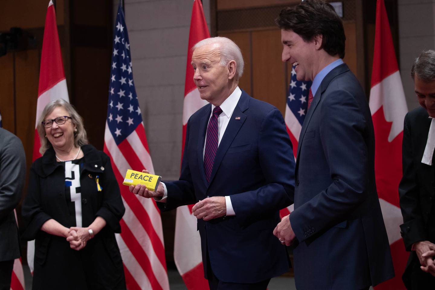 US President Joe Biden, center, holds a Peace by Chocolate bar gifted to him by Elizabeth May, leader of the Green Party, left, on Parliament Hill in Ottawa, Ontario, Canada, on Friday, March 24, 2023. Photographer: David Kawai/Bloomberg
