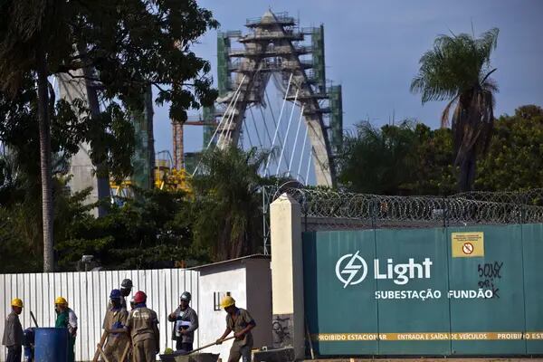 Public works employees labor at a construction site in front a Light SA electricity substation in Rio de Janeiro, Brazil