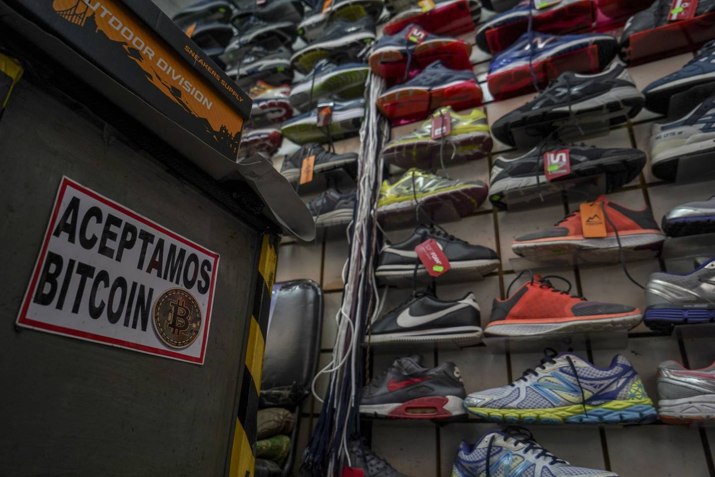 A sign announcing the acceptance of Bitcoin as a payment method at a shoe store in San Salvador.