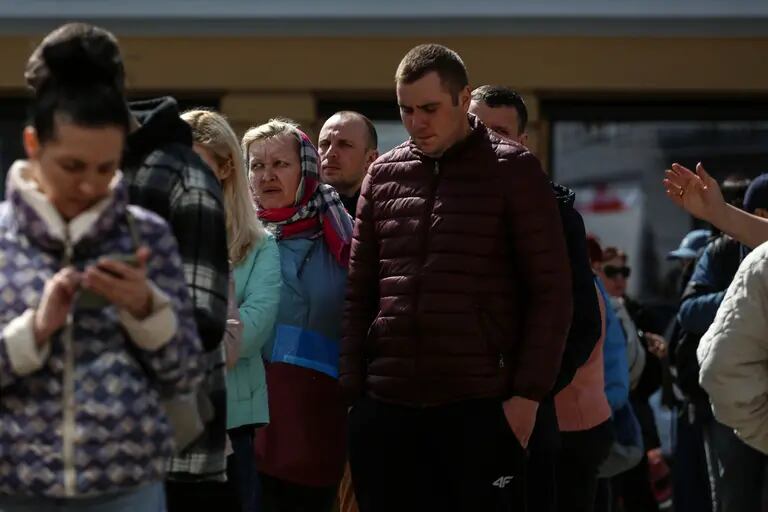 Ucranianos desplazados esperan para recoger las provisiones donadas frente a una antigua escuela, utilizada como centro humanitario y de donaciones, en Odesa.dfd
