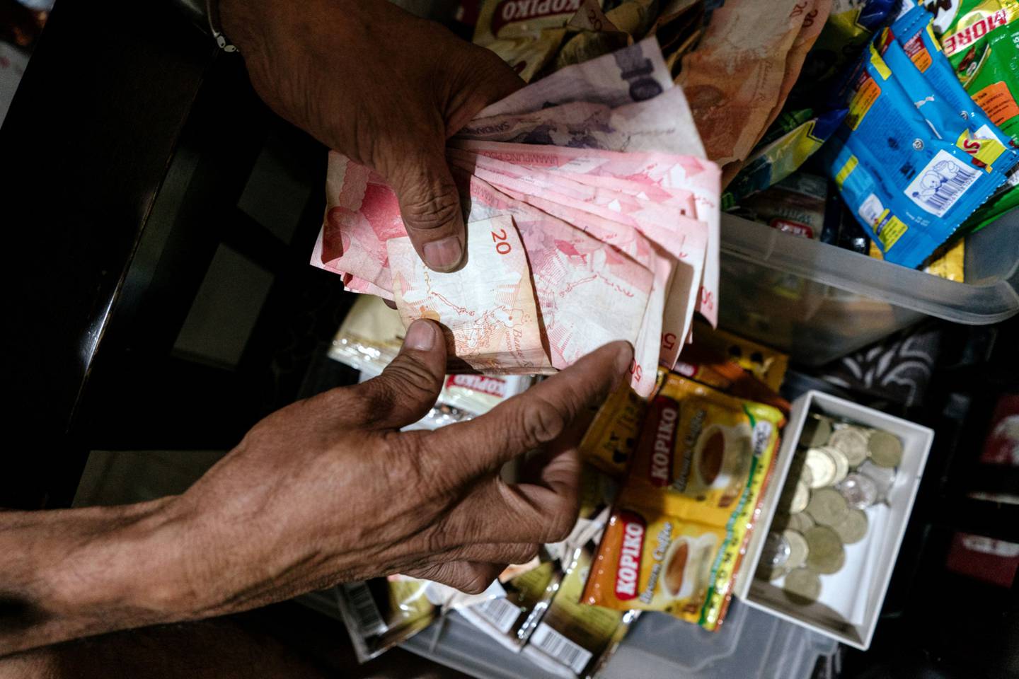 Una persona cuenta billetes del peso filipino