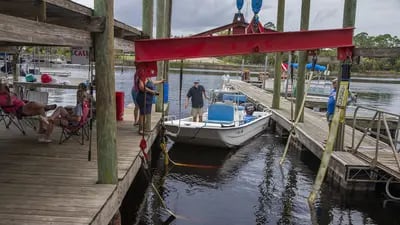 Los pescadores hacen fila para tirar de su bote en el río Steinhatchee mientras la lluvia amenaza antes de la llegada de la tormenta tropical Elsa a Florida.