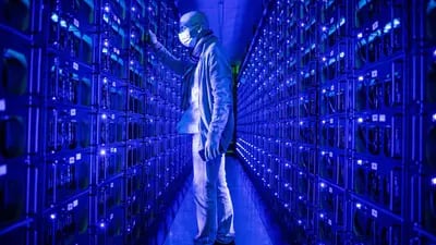 An employee wearing a protective face mask inspects mining rigs mining the Ethereum and Zilliqa cryptocurrencies at the Evobits crypto farm in Cluj-Napoca, Romania, on Wednesday, Jan. 22, 2021.