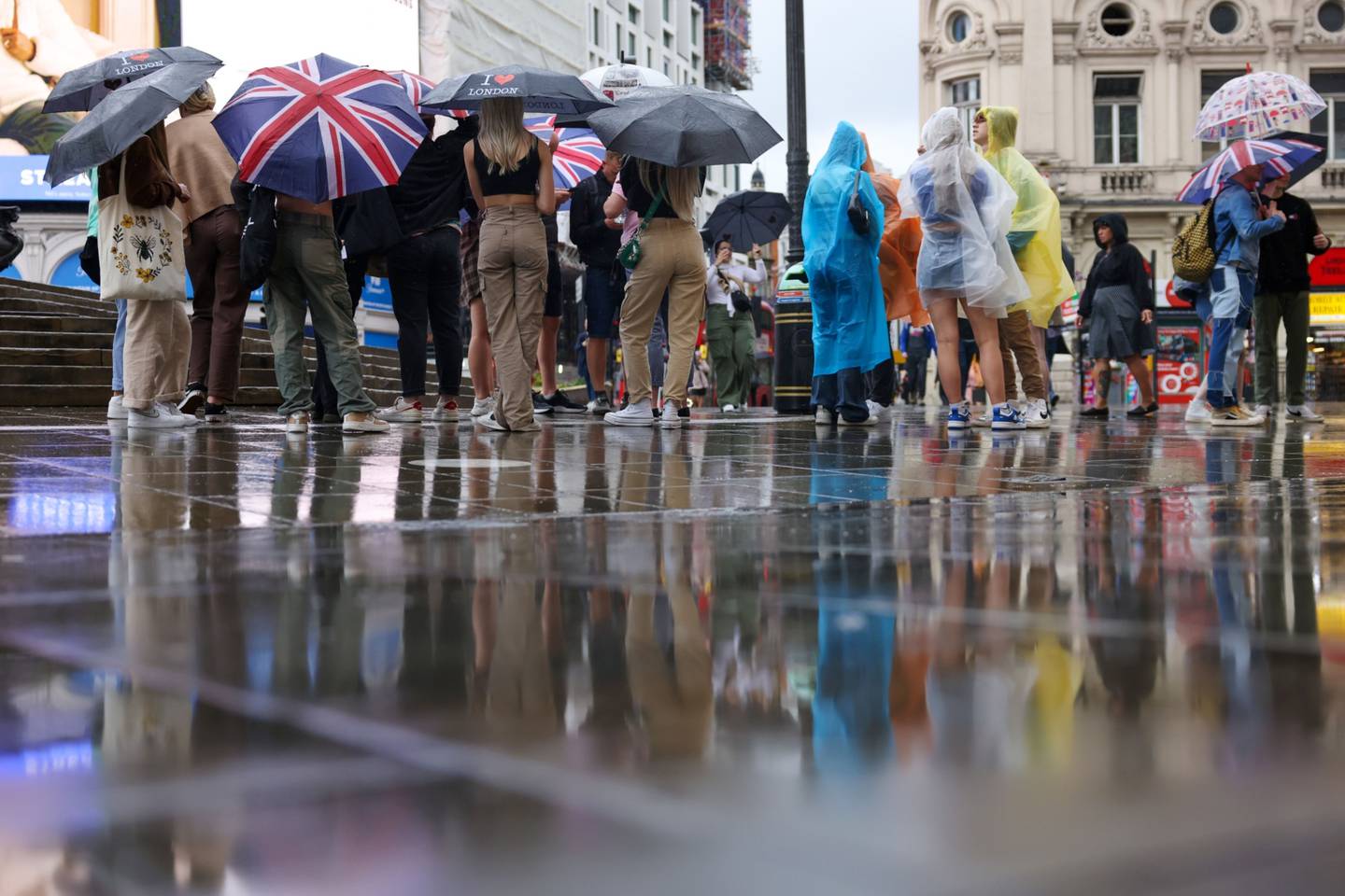Turistas se protegen de la lluvia bajo paraguas en Piccadilly Circus, en el centro de Londres, Reino Unido, el miércoles 29 de junio de 2022. Regent Street, la principal arteria comercial de Londres, lucha por sacudirse los efectos persistentes de Covid-19. Fotógrafo: Hollie Adams/Bloomberg