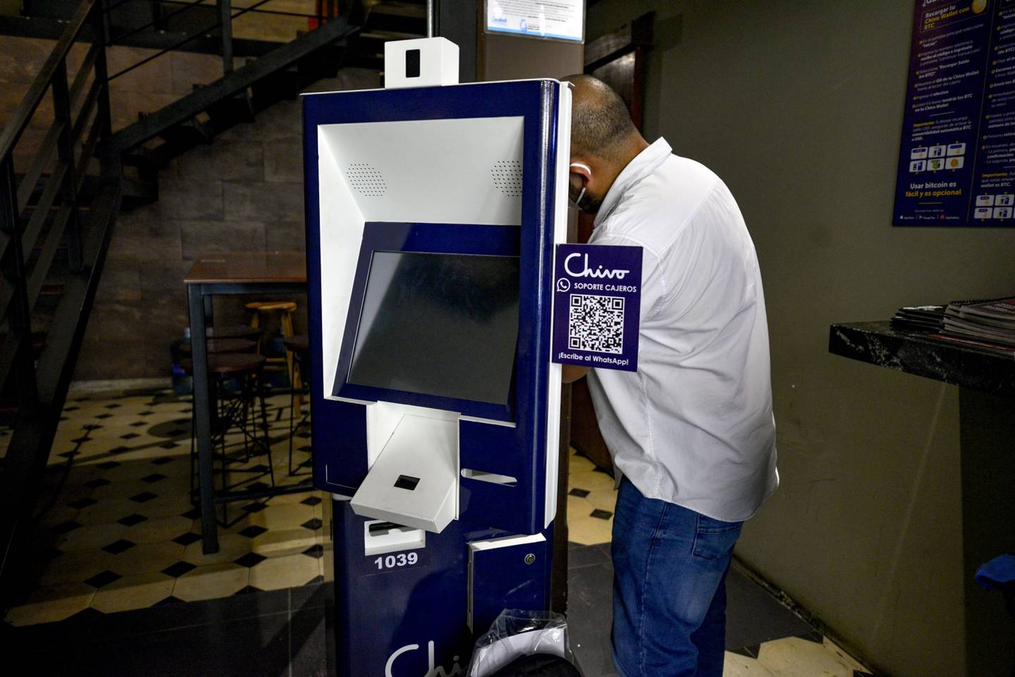 Un trabajador arregla un cajero automático de Chivo, la billetera digital de El Salvador.