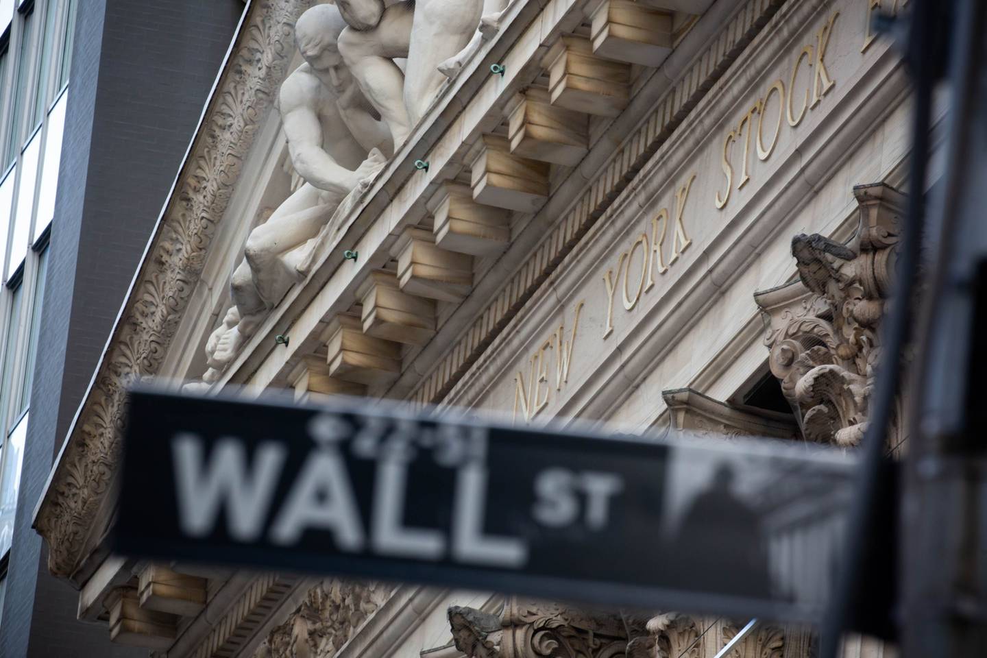 A Wall Street street sign in front of the New York Stock Exchange (NYSE) in New York, U.S.