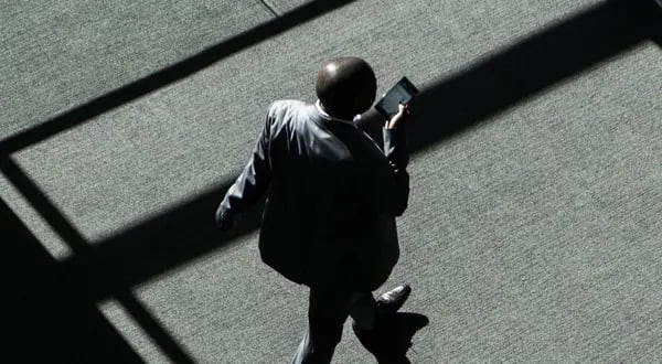 Un asistente navega por un dispositivo smartphone en los pasillos de la convención entre las sesiones del segundo día del 28º Foro Económico Mundial (FEM) sobre África en Ciudad del Cabo, Sudáfrica, el jueves 5 de septiembre de 2019.