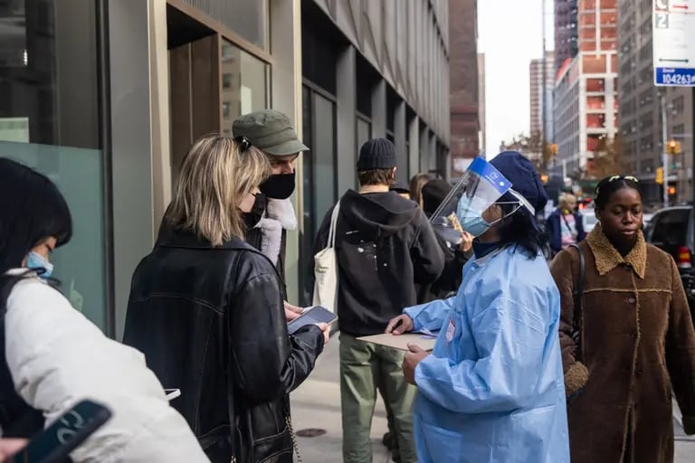 Un trabajador de salud ayuda a los residentes en un lugar de vacunación contra el Covid-19 en el barrio de Chinatown de Nueva York, el domingo 5 de diciembre de 2021.dfd