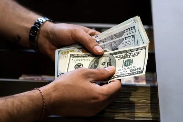 Un empleado cuenta billetes de 100 dólares estadounidenses en Estambul, Turquía, el jueves 8 de junio de 2023