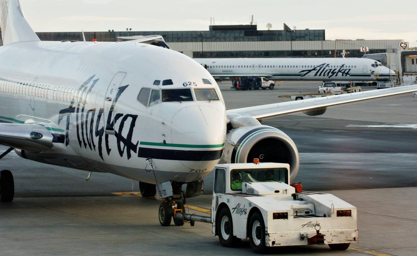 Un avión de Alaska Airlines es empujado hacia atrás desde una puerta de embarque en el Aeropuerto Internacional Ted Stevens de Anchorage.dfd