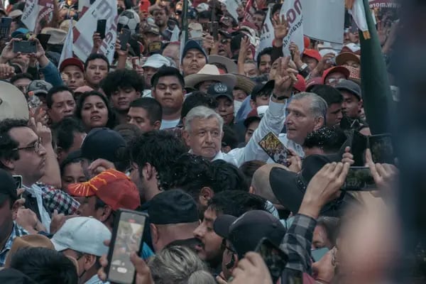 AMLO (centro) saluda a los asistentes durante la marcha que convocó en el centro de Ciudad de México el domingo 27 de noviembre de 2022, en defensa de su reforma electoral y para conmemorar su cuarto año en el Gobierno.