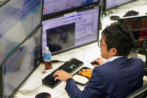 Un agente trabaja mientras almuerza en la sala de operaciones de la empresa de corretaje de divisas Gaitame.Com Co. en Tokio, Japón, el jueves 20 de octubre de 2022. Fotógrafo: Toru Hanai/Bloomberg