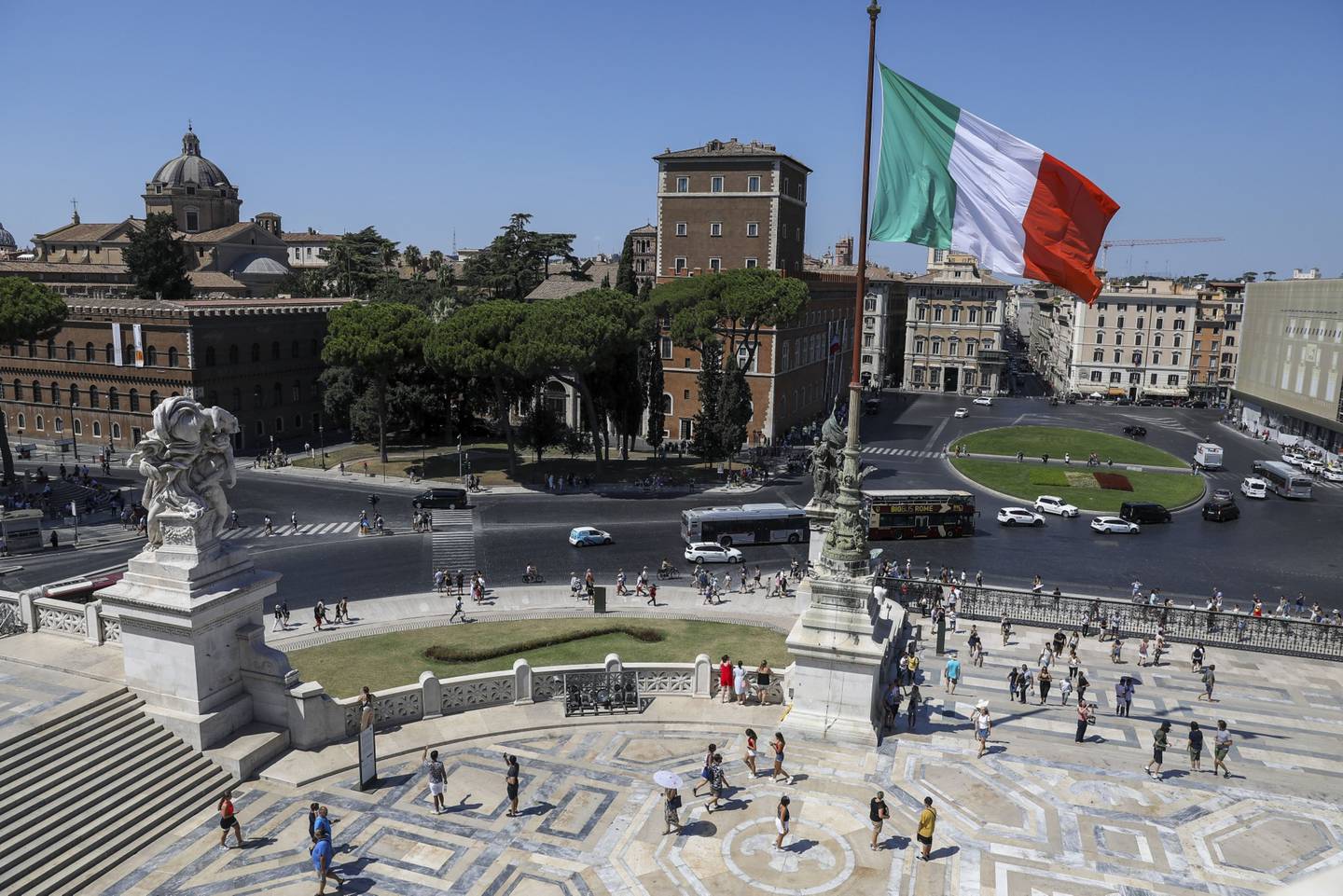 The Italian national flag flies near a monument to the unknown soldier in Rome, Italy, on Wednesday, Aug. 21, 2019. Italian President Sergio Mattarella begins intensive talks with political leaders Wednesday to determine whether a new ruling coalition is viable, as the head of one of the countrys main parties signaled willingness to explore a new parliamentary majority. Photographer: Alessia Pierdomenico/Bloomberg
