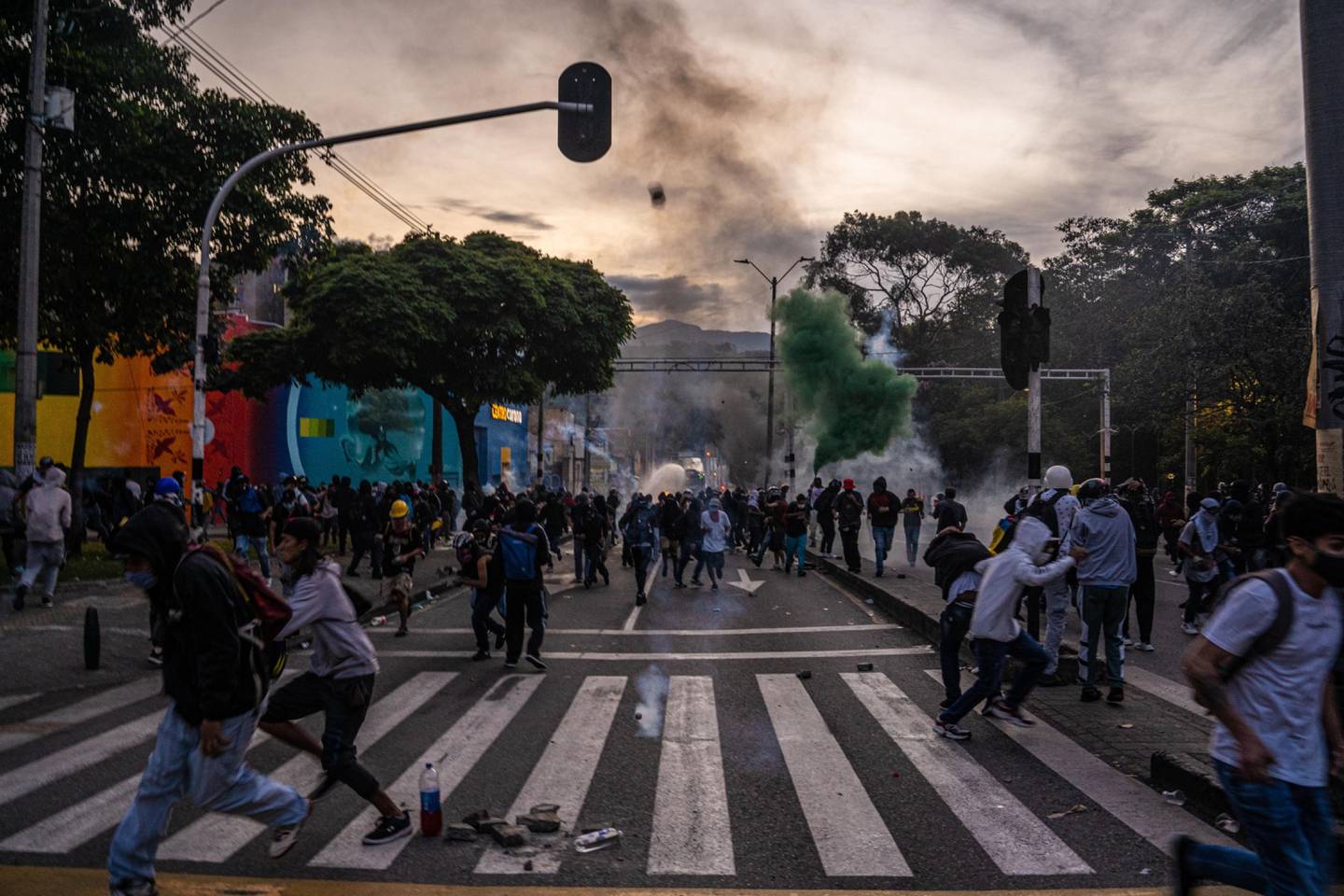 Los manifestantes huyen de los gases lacrimógenos mientras chocan con la Policía antidisturbios durante las protestas en Medellín, Colombia, el sábado 22 de mayo de 2021. Las protestas a nivel nacional han continuado estallando en Colombia durante más de 3 semanas, mientras el Gobierno enfrenta una ola de críticas por su uso de tácticas policiales de mano dura.