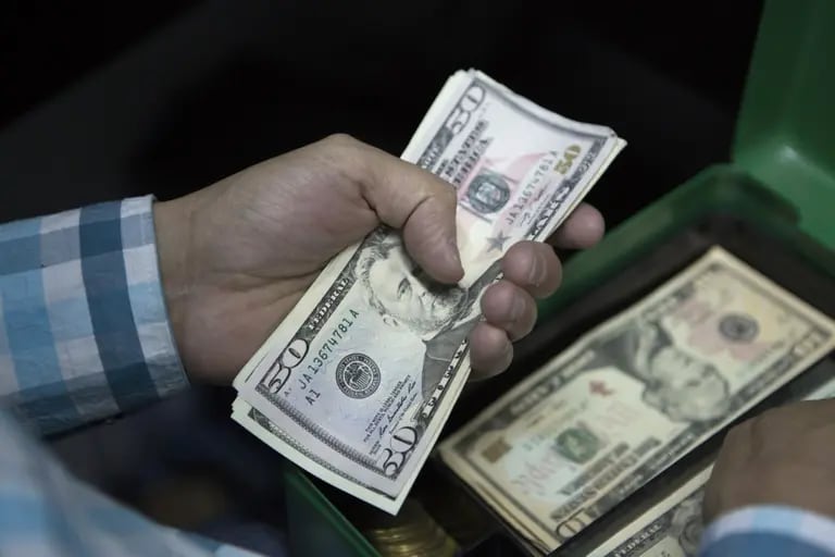 Un empleado cuenta billetes de cincuenta dólares estadounidenses en una casa de cambio.dfd