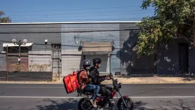 Delivery workers rides a motorcycle during lockdown in Santiago, Chile, on Monday, March 29, 2021. Chile has been vaccinating its population much faster than all other countries in Latin America, with more than 6 million inoculated, though the nation has still seen its daily record number of cases increase. Photographer: Cristobal Olivares/Bloomberg