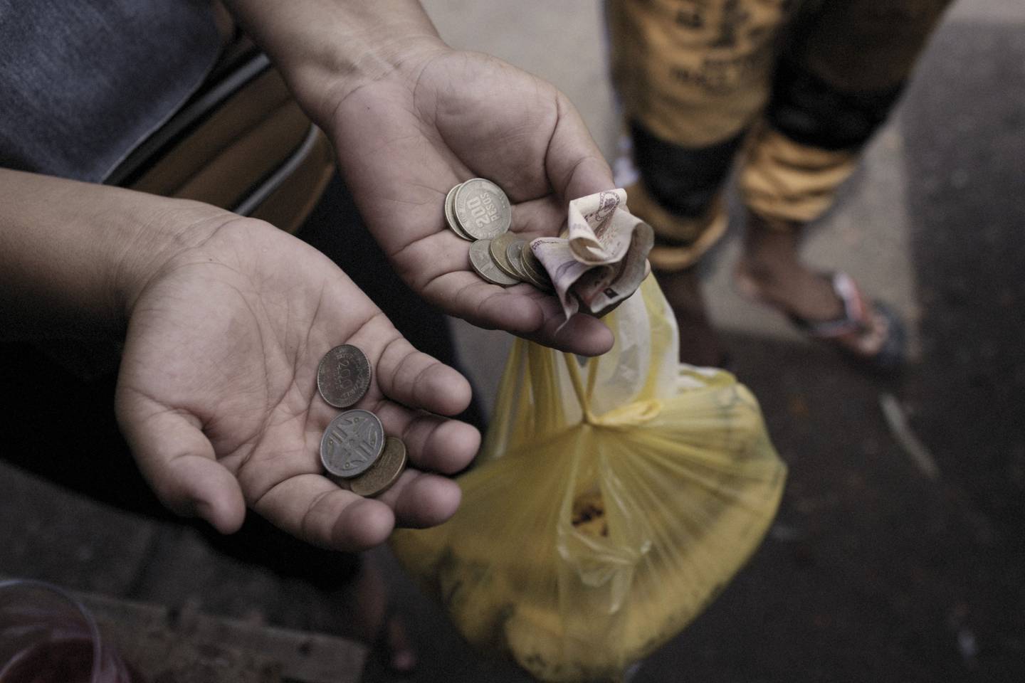 Un comprador sostiene dinero en efectivo en un mercado de alimentos en Riohacha, Colombia, el sábado 13 de agosto de 2022.