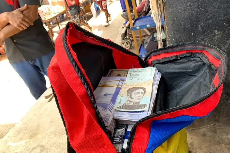 Un vendedor ambulante con una mochila de bolívares venezolanos en un mercado público en Puerto la Cruz, Venezuela. Fotógrafo: Manaure Quintero/Bloomberg

dfd
