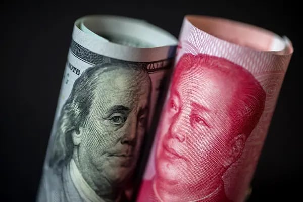Un billete de cien dólares de EE.UU. se encuentra junto a un billete chino de cien yuanes sobre un fondo negro en esta fotografía arreglada en Hong Kong, China. Fotógrafo: Paul Yeung/Bloomberg