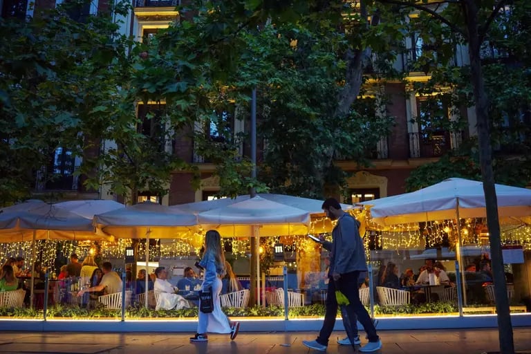 Pedestrians pass customers dining on a restaurant terrace in the Salamanca district of Madrid, Spain, on Saturday, May 27, 2023. A flood of funds from well-heeled Latin Americans is changing the face of Madrid: driving property prices soaring and creating a sizzling hot high-end dining scene.dfd