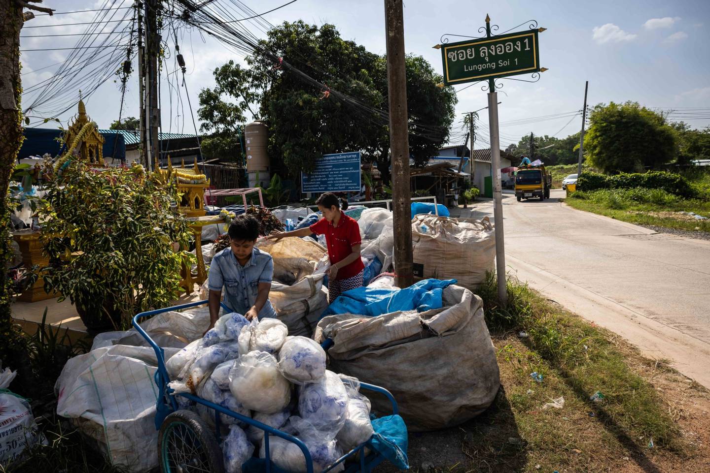 Voluntarios llenan un carro con residuos plásticos para su clasificación en un centro de reciclaje de Rayong, Tailandia, el miércoles 14 de diciembre de 2022.