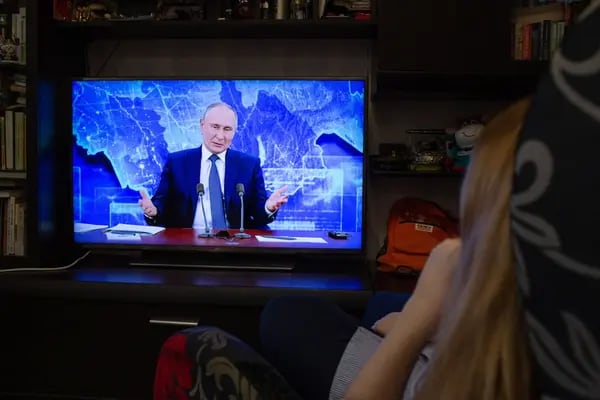 A resident watches a live broadcast of Vladimir Putin, Russia's President, delivering his annual address on a television in Moscow, Russia, on Thursday, Dec. 17, 2020. Putin sent Joe Biden a congratulatory telegram after the Electoral College formalized his victory in the Nov. 3 election, making him among the last world leaders to recognize the U.S. president-elect. Photographer: Andrey Rudakov/Bloomberg