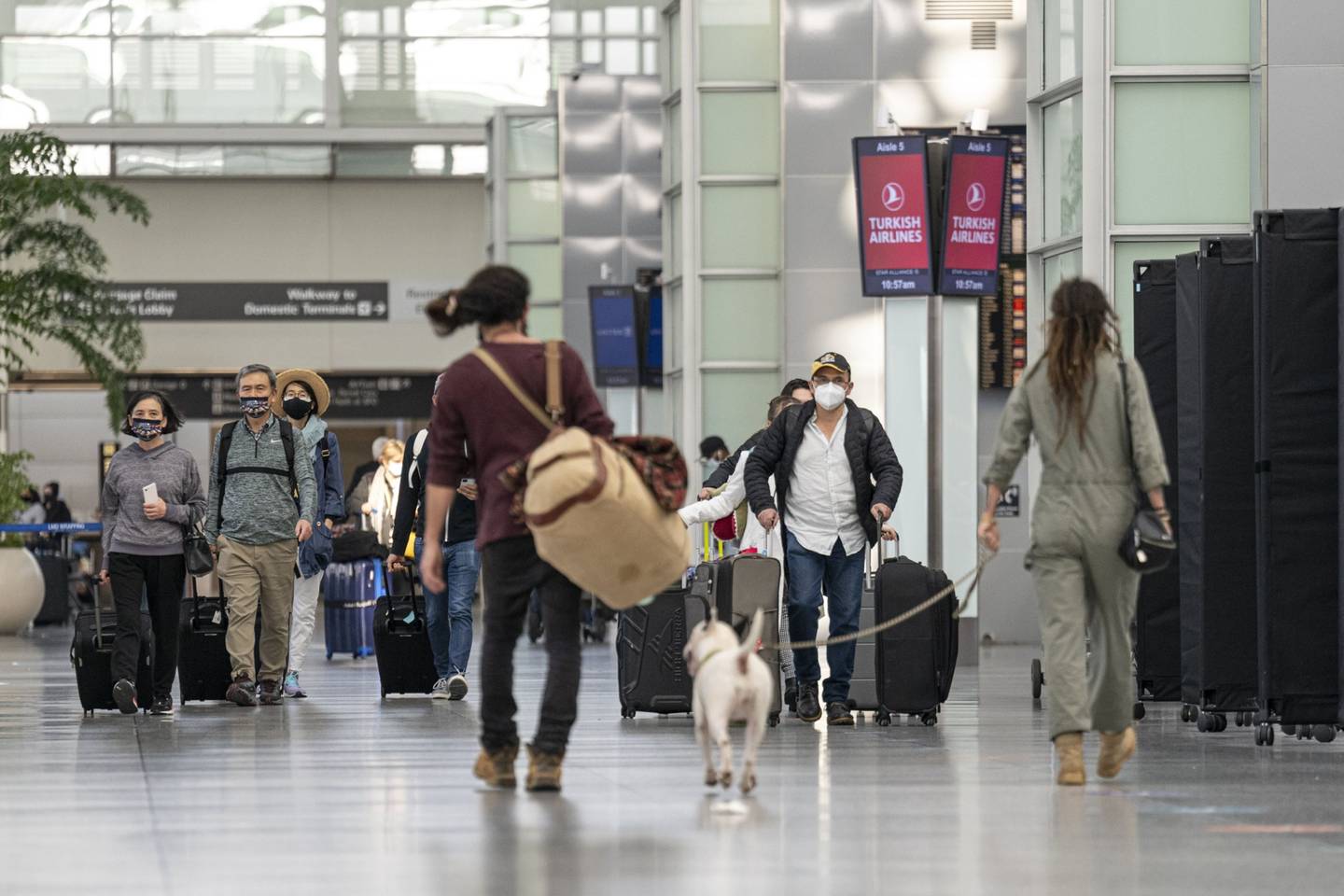 Viajeros pasan frente a un centro de pruebas de Covid-19, en la terminal internacional del Aeropuerto Internacional de San Francisco.