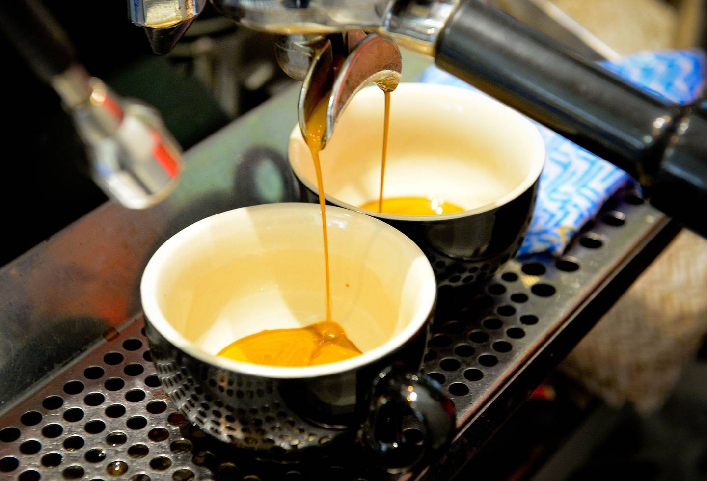 Un espresso sale de una máquina y se vierte en tazas.