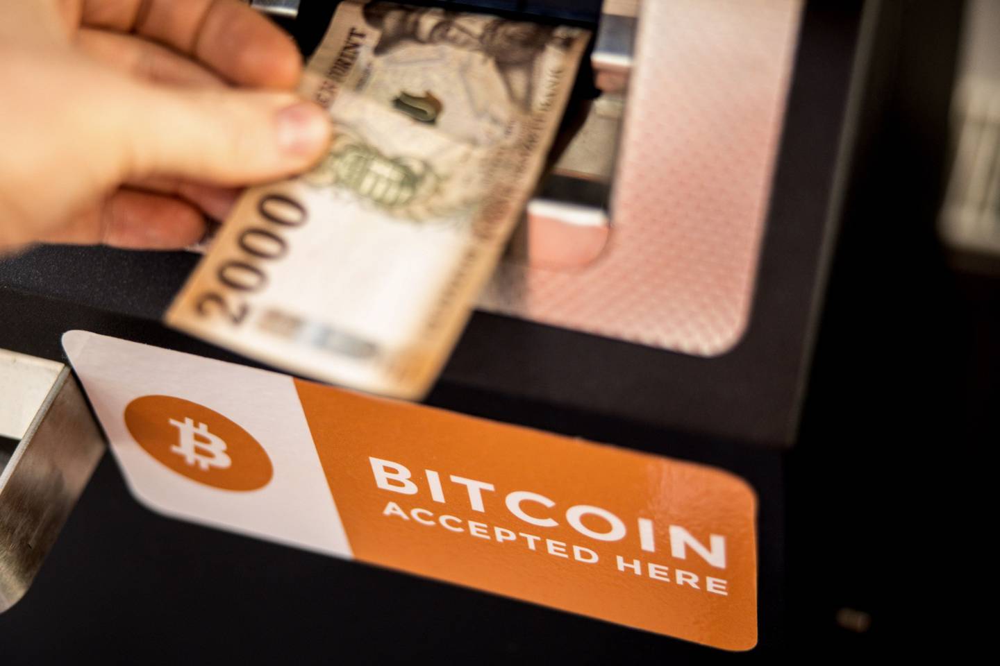 A customer deposits a Hungarian twenty thousand forint banknote into a cryptocurrency automated teller machine (ATM) in Budapest, Hungary, on Friday, Feb. 18, 2022. Bitcoin is testing $40,000, a key psychological level, as the U.S. plan talks with Russia about military intelligence that suggests an imminent Ukraine invasion, which it denies. Photographer: Akos Stiller/Bloomberg