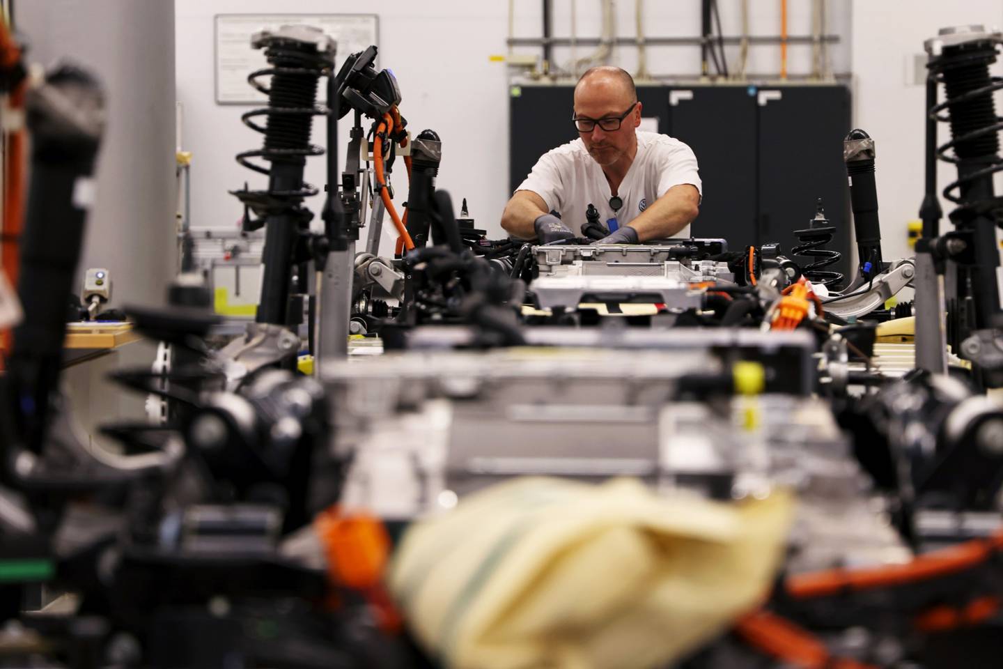 Un trabajador ajusta un paquete de baterías a un automóvil eléctrico ID.3 de Volkswagen AG (VW) en la línea de montaje de la fábrica, en Dresde, Alemania, el martes 8 de junio de 2021.