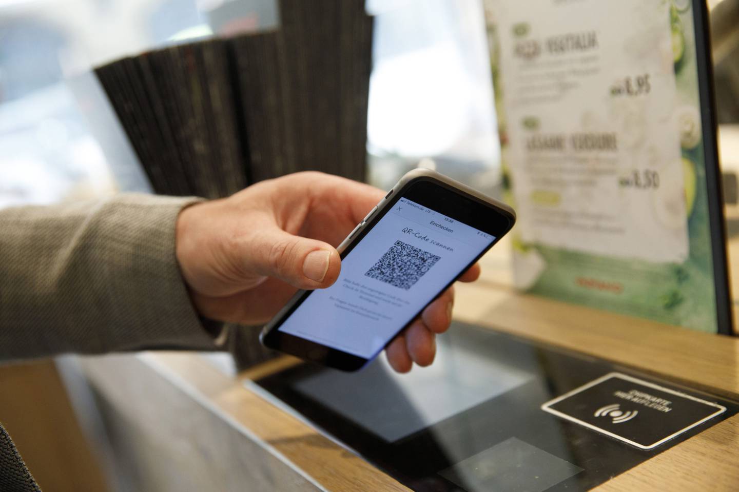 Un cliente escanea un código QR en su smartphone para pagar su pedido.dfd