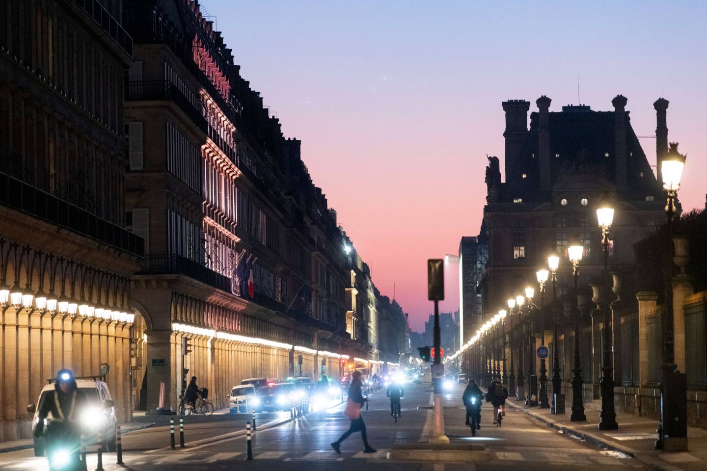 Commuters at Rivoli Street during sunrise in Paris.