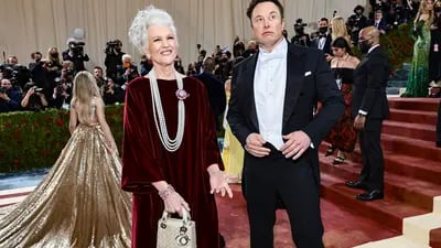 A modelo Maye Musk, com vestido Dior bordô e bolsa Dior, chegou com o filho Elon Musk.