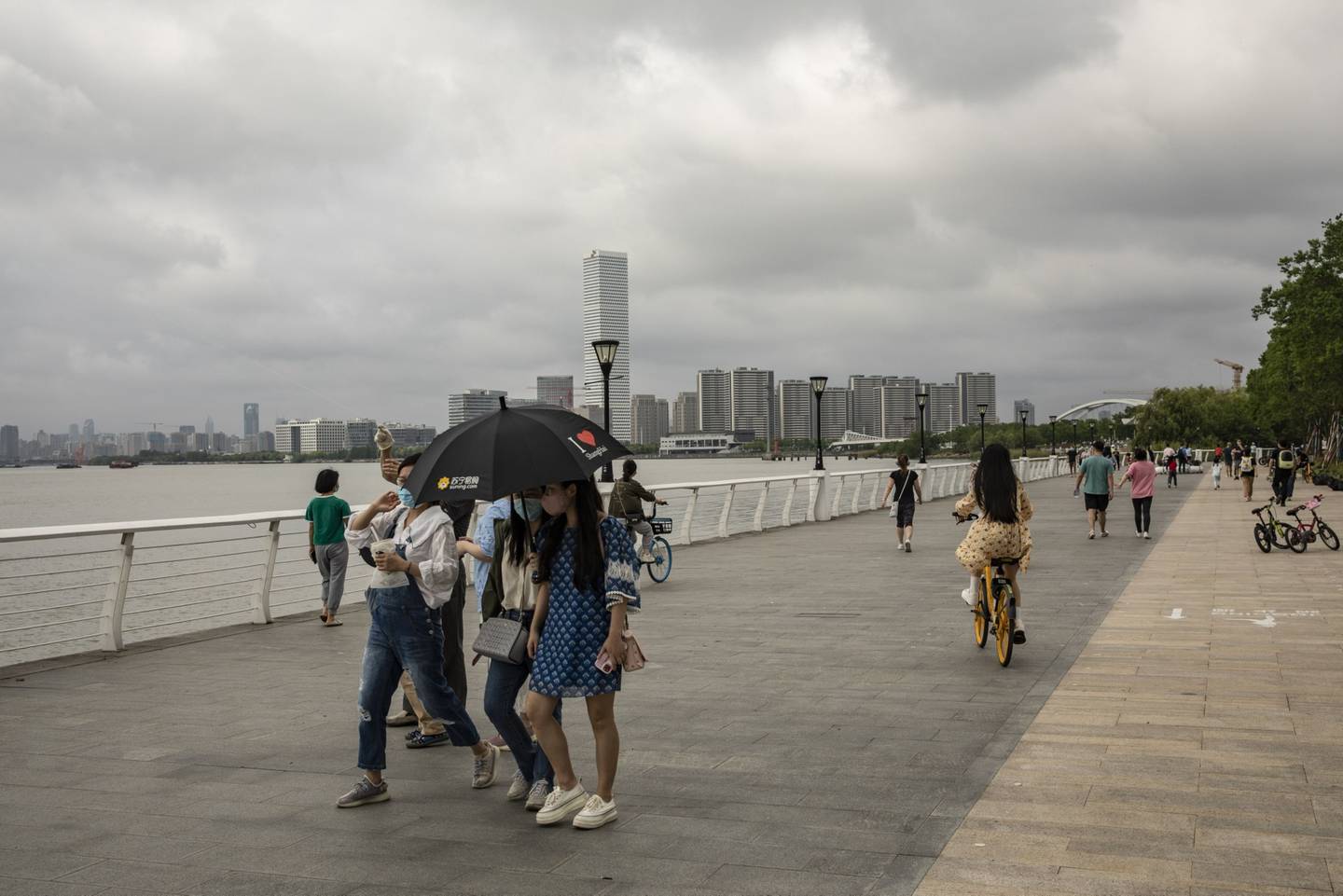 Personas caminan a lo largo de un paseo marítimo en Shanghai, China, el sábado 4 de junio de 2022.