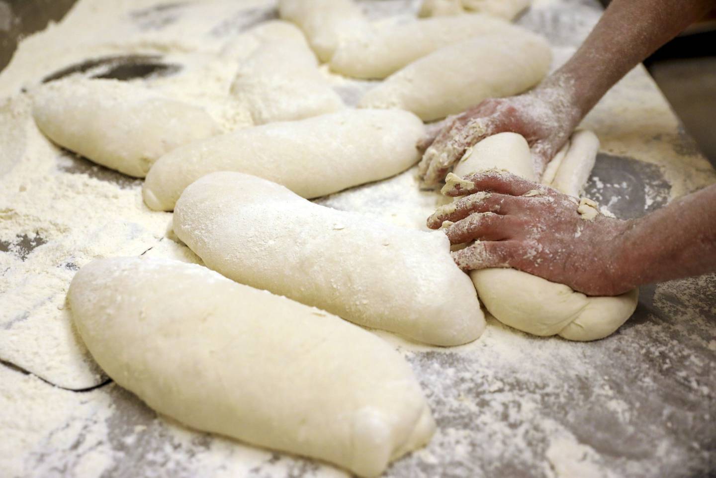 A baker kneads dough by hand while making bread at a bakery in Rome, Italy, on Wednesday, March 9, 2022. Wheat futures swung wildly between gains and losses Tuesday after climbing to unprecedented heights as Russia's attack on Ukraine disrupts global food supplies. Photographer: Alessia Pierdomenico/Bloomberg