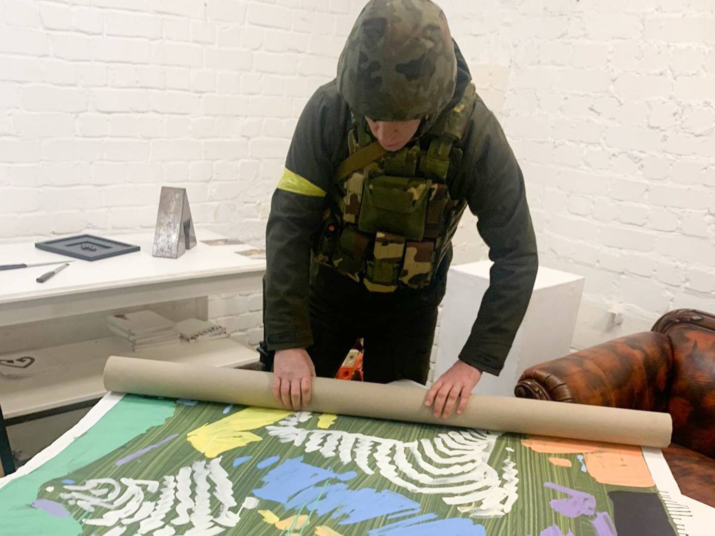 An art collector-turned-civil defense fighter helps roll up art for safekeeping.