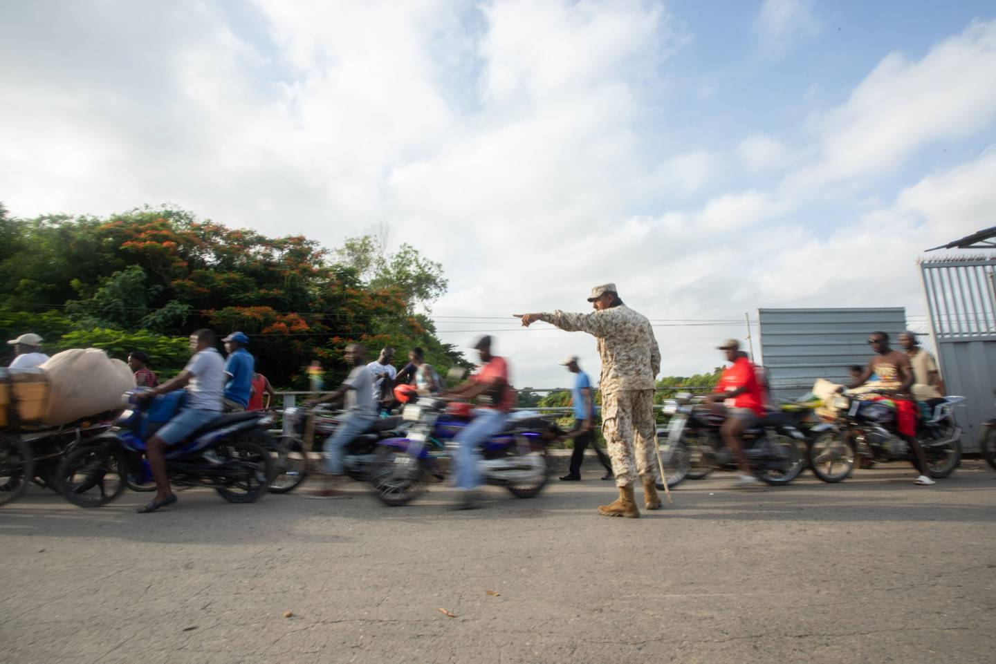 A Specialized Corps of Land Border Security agents directs Haitians entering a border crossing in Dajabón.dfd