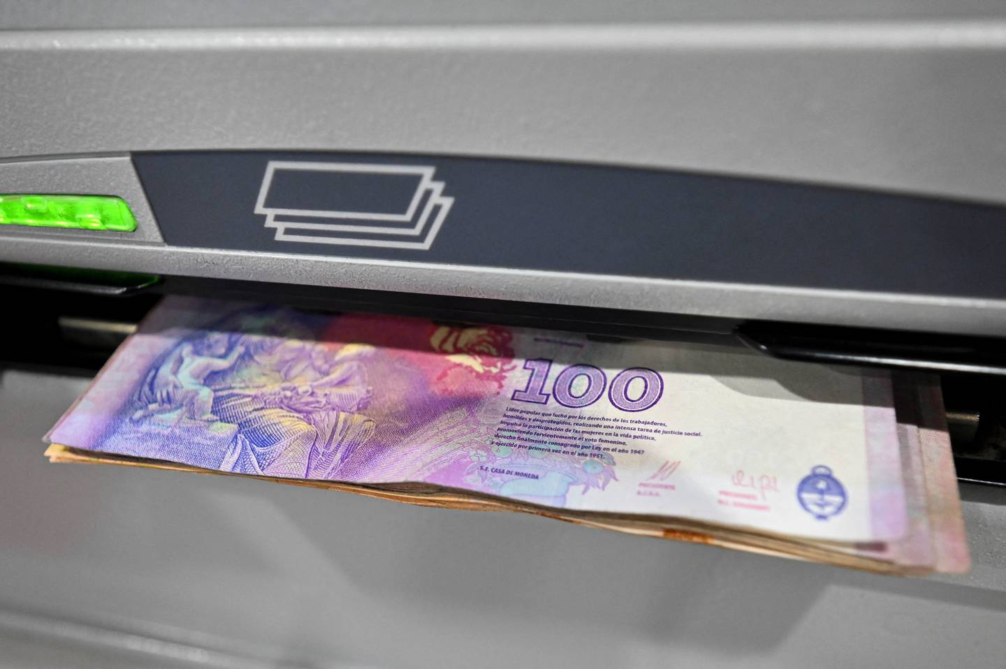 Argentine peso notes at an ATM machine.