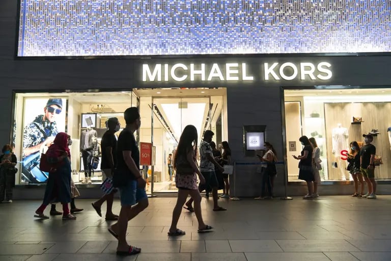 People line up outside the Michael Kors store on Orchard Road in Singapore, on Saturday, July 25, 2020. Singapores economy plunged into recession last quarter as an extended lockdown shuttered businesses and decimated retail spending, a sign of the pain the pandemic is wreaking across export-reliant Asian nations. Photographer: Wei Leng Tay/Bloombergdfd