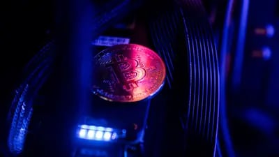 Un token que representa la moneda virtual bitcoin se encuentra entre los cables y la iluminación LED dentro de una computadora de "plataforma de minería" en esta fotografía arreglada en Budapest, Hungría, el miércoles 31 de enero de 2018.  Fotógrafo: Akos Stiller/Bloomberg