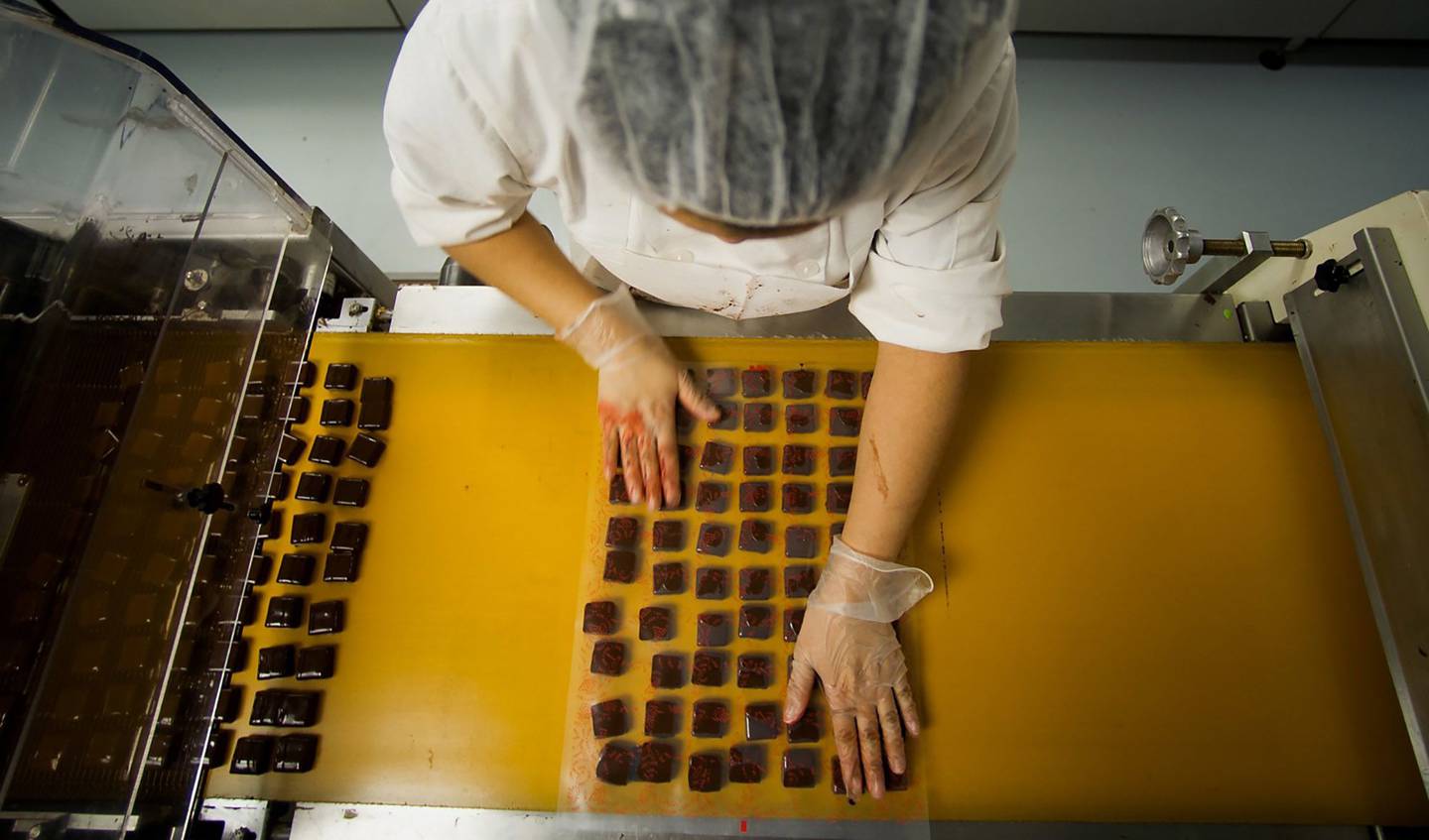 Los chocolates salen de una máquina después de recibir una capa en una fábrica de Brooklyn, Nueva York. Fotógrafo: Ron Antonelli/Bloomberg
