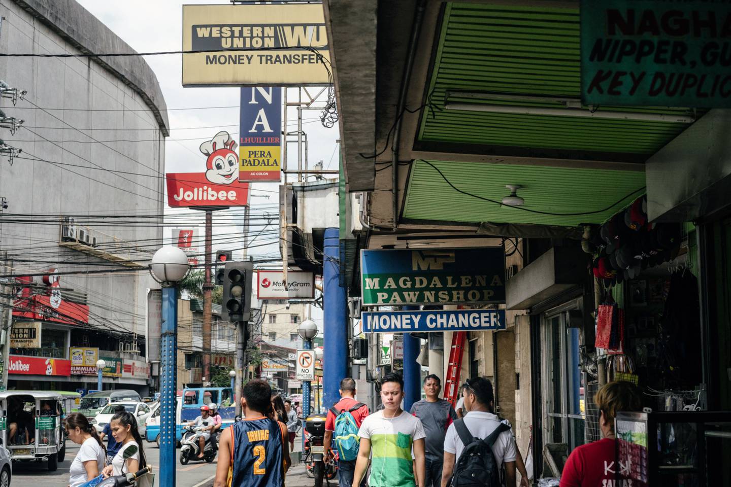 Los peatones pasan por delante de las casas de empeño y los centros de envío de dinero en Manila.