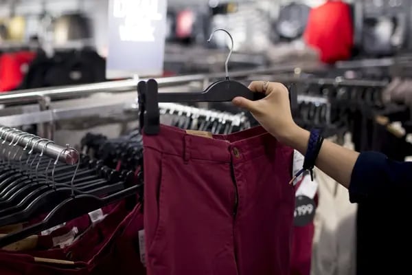 Un cliente mira un par de pantalones dentro de una tienda de Hennes & Mauritz AB (H&M) en el distrito de Tsim Sha Tsui de Hong Kong, China, el viernes 24 de octubre de 2014.