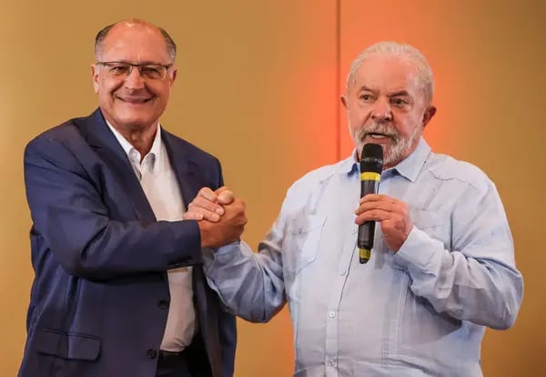 Presidential candidate Lula, right, shakes hands with Geraldo Alckmin after announcing him as a running mate during a press conference in Sao Paulo on April 8, 2022.
